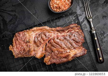 BBQ grilled Chuck eye roll steak, prime beef meat on a steel rack. black background. top view BBQ grilled Chuck eye roll steak, prime beef meat on a steel rack. black background. top view 122869853