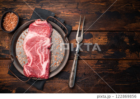 Prime Raw Chuck eye roll steak, fresh beef meat in steel tray. wooden background. top view 122869856