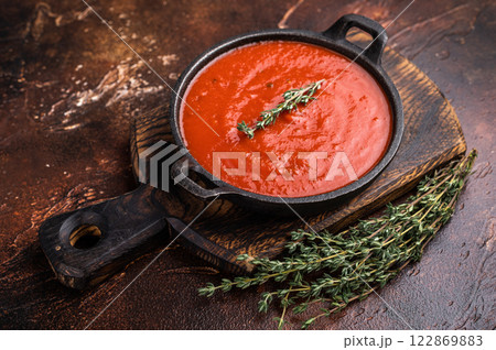 Tomato sauce passata in a skillet , traditional recipe of italian cuisine. brown background. top view 122869883