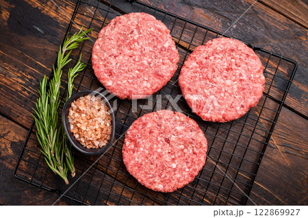 Raw meat patties, cutlets, chopped meat for burgers. wooden background. top view Raw meat patties, cutlets, chopped meat for burgers. wooden background. top view 122869927