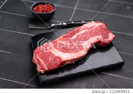 Raw Chuck eye roll steak, fresh prime beef meat. black background. top view 122869953