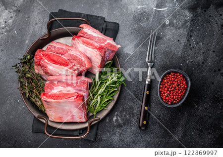 Raw Beef Short Rib, uncooked meat with bone and fat. black background. top view Raw Beef Short Rib, uncooked meat with bone and fat. black background. top view 122869997
