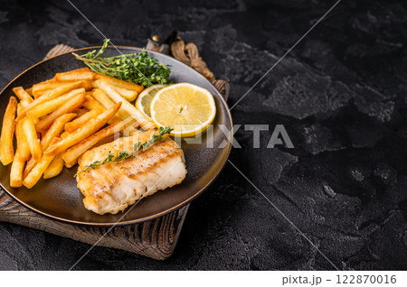 Homemade Fish and chips with roast cod whitefish fillet and fried potatoes on plate. black background. top view Homemade Fish and chips with roast cod whitefish fillet and fried potatoes on plate. black background. top view 122870016