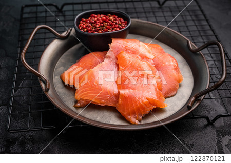 Salty salmon, trout fillet slices on steel tray. black background. top view 122870121