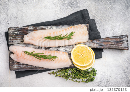 Raw cod Loin, white fish fillets without skin on wooden board. white background. top view 122870128