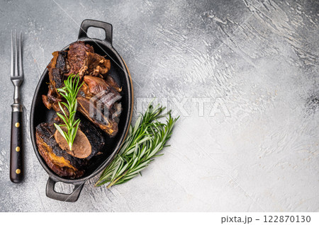 Grilled beef short ribs glistening under natural Beef short ribs slow-cooked to perfection, served on a stylish plate with vibrant sides, showcasing a delicious and hearty meal. grey background. Grilled beef short ribs glistening under natural Beef short ribs slow-cooked to perfection, served on a stylish plate with vibrant sides, showcasing a delicious and hearty meal. grey background. 122870130