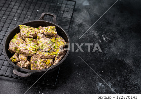 Oriental Halva with pistachio in a skillet. Natural vegan sweets. black background. top view. 122870143