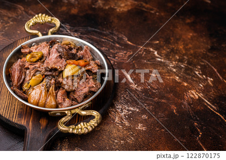 Slow cooked Beef Cheek, Braised meat with vegetables in a skillet. brown background. top view 122870175