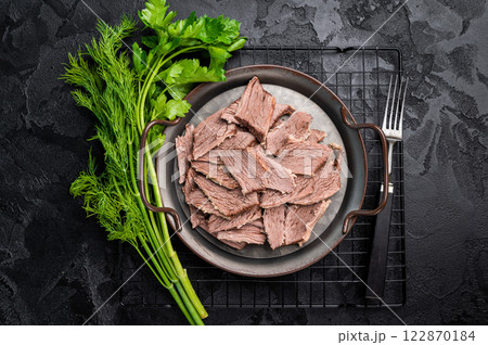 Boiled sliced beef meat in a steel tray. black background. top view 122870184