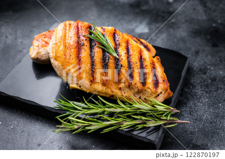 Grilled chicken breasts steaks with rosemary, farm poultry meat, top view, black background. Grilled chicken breasts steaks with rosemary, farm poultry meat, top view, black background. 122870197