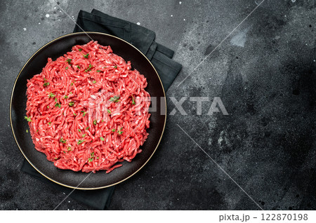Lamb Mutton ground mince raw meat, forcemeat on a black plate, top view. Lamb Mutton ground mince raw meat, forcemeat on a black plate, top view. 122870198