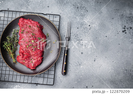Marinated Skirt machete steak, raw beef meat with thyme and spices on plate. grey background. top view 122870209