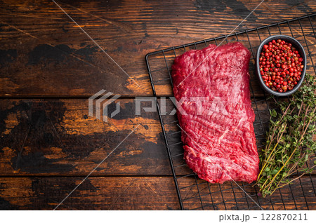 Raw flank steak, beef meat ready for BBQ. wooden background. top view 122870211
