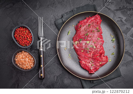 Marinated Flank or Flap steak, raw beef meat with thyme and spices on plate. black background. top view 122870212