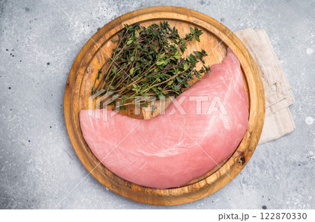 Fresh turkey breast fillet, raw poultry meat with herbs for cooking. grey background. top view Fresh turkey breast fillet, raw poultry meat with herbs for cooking. grey background. top view 122870330