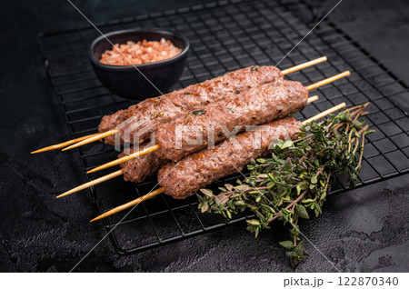 Grilled Cevapcici skewers, Cevapi sausages from mince beef and pork meat. black background. top view Grilled Cevapcici skewers, Cevapi sausages from mince beef and pork meat. black background. top view 122870340