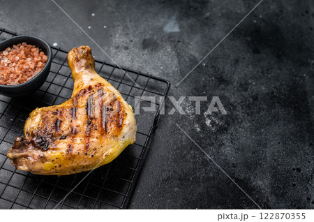Grilled chicken leg with Thigh, roasted poultry meat on black background, top view Grilled chicken leg with Thigh, roasted poultry meat on black background, top view 122870355