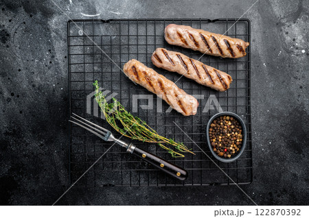 BBQ Grilled beef and pork sausages on steel rack. black background. top view 122870392