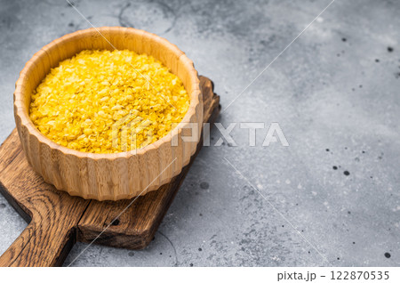 Millet flakes in wooden bowl, rolled millet for porridge and muesli. grey background. top view 122870535