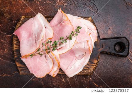 Ham Prosciutto Cotto, Sliced Pork Ham on wooden board. brown background. top view Ham Prosciutto Cotto, Sliced Pork Ham on wooden board. brown background. top view 122870537