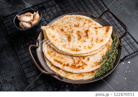 Aloo Paratha Indian Potato stuffed Flatbread. black background. top view Aloo Paratha Indian Potato stuffed Flatbread. black background. top view 122870551