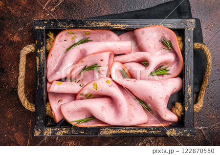 Mortadella Bologna slices with pistachios for breakfast in wooden. brown background. top view Mortadella Bologna slices with pistachios for breakfast in wooden. brown background. top view 122870580
