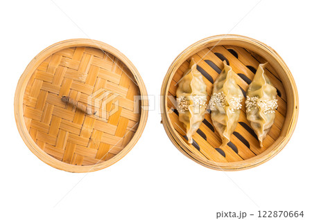 Steamed Korean dumplings with pork meat and vegetables in bamboo steamer isolated on white background. top view Steamed Korean dumplings with pork meat and vegetables in bamboo steamer isolated on white background. top view 122870664