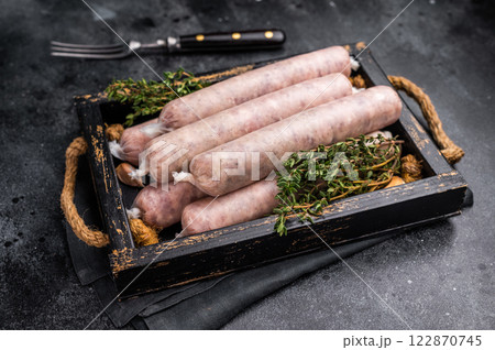 Raw Sausages with minced chicken and turkey meat with herbs in wooden tray. black background. top view Raw Sausages with minced chicken and turkey meat with herbs in wooden tray. black background. top view 122870745