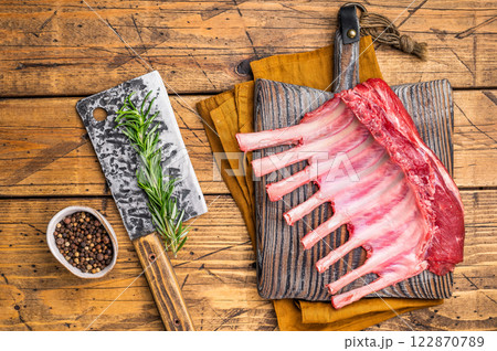 Butcher board with Raw lamb meat for chops steaks, fresh rack of mutton. wooden background. top view Butcher board with Raw lamb meat for chops steaks, fresh rack of mutton. wooden background. top view 122870789
