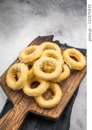 Raw and frozen squid rings with breading, uncooked calamari snack. white background. top view Raw and frozen squid rings with breading, uncooked calamari snack. white background. top view 122870930