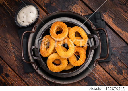 Crispy Fried squid rings, calamari fastfood snack. wooden background. top view Crispy Fried squid rings, calamari fastfood snack. wooden background. top view 122870945