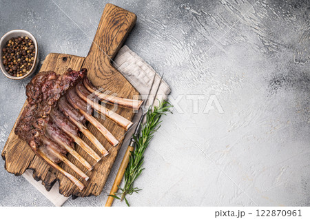 Grilled Rack of lamb, mutton meat chop steaks on wooden board. grey background. top view 122870961
