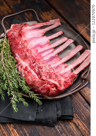 Fresh rack of lamb, raw mutton meat for chops steaks on steel tray. wooden background. top view 122870970