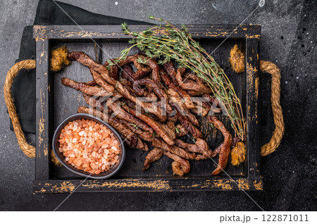 Beef fritter, Deep fried beef tender strips, sliced meat in a tray. black background. top view Beef fritter, Deep fried beef tender strips, sliced meat in a tray. black background. top view 122871011