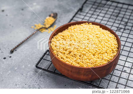 Raw stelline pasta, uncooked Italian soup Noodle in a bowl. grey background. top view 122871066
