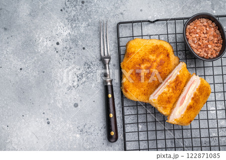 Fried Chicken cordon bleu cutlet with cheese and ham in breadcrumbs. grey background. top view Fried Chicken cordon bleu cutlet with cheese and ham in breadcrumbs. grey background. top view 122871085