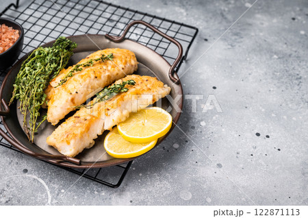 Baked Cod fish fiilet, fried whitefish meat. Grey background. top view Baked Cod fish fiilet, fried whitefish meat. Grey background. top view 122871113