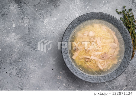 Chicken soup with Vermicelli and meat in a plate. grey background. top view Chicken soup with Vermicelli and meat in a plate. grey background. top view 122871124