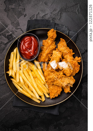 Deep fried chicken strips, sticks with french fry and sauce. black background. top view Deep fried chicken strips, sticks with french fry and sauce. black background. top view 122871126