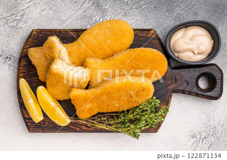 Deep fried Fish fingers on wooden board. white background. top view 122871134