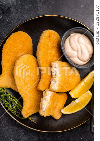 Crispy fried cod Fish sticks on plate. black background. top view Crispy fried cod Fish sticks on plate. black background. top view 122871137