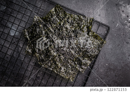 Dried Nori seaweed sheets on a rack. black background. top view 122871153
