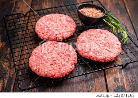 Raw meat patties, cutlets, chopped meat for burgers. wooden background. top view 122871165