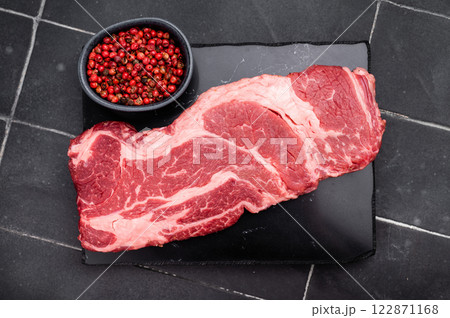 Raw Chuck eye roll steak, fresh prime beef meat. black background. top view 122871168