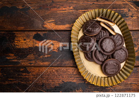 Steel plate with Jaffa Cookies covered with chocolate and filled with jam. Wooden background. top view Steel plate with Jaffa Cookies covered with chocolate and filled with jam. Wooden background. top view 122871175