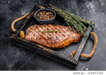 BBQ roast New York strip steak, striploin beef meat steak. black background. top view BBQ roast New York strip steak, striploin beef meat steak. black background. top view 122871191