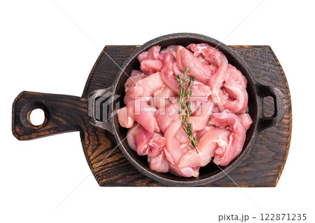 Raw Chicken sliced thighs fillets in a skillet isolated on white background Raw Chicken sliced thighs fillets in a skillet isolated on white background 122871235