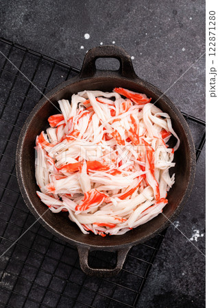 japanese Crab meat, crabmeat imitation in a skillet. black background. top view japanese Crab meat, crabmeat imitation in a skillet. black background. top view 122871280