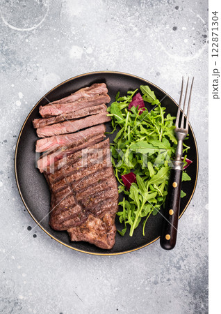 Barbecue dry aged wagyu entrecot steak on plate with salad. grey background. top view Barbecue dry aged wagyu entrecot steak on plate with salad. grey background. top view 122871304