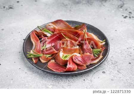 Meat appetizer dried duck breast fillet meat slices, magret smoked poultry. grey background. top view 122871330